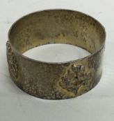 A rare silver gilt napkin ring embossed with thistles, flowers and a Royal coat of arms.