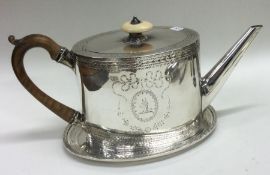 A good 18th Century bright cut George III silver crested teapot on stand. London 1781.