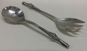 A pair of silver salad servers in the style of Georg Jensen.