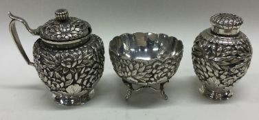YOKOHAMA: A 19th Century Japanese silver three piece condiment set with chased decoration.