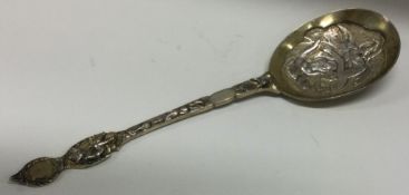 A Victorian chased silver gilt dessert spoon embossed with vines and angels.