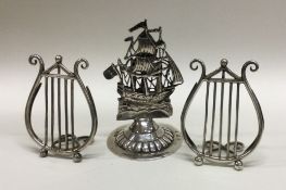 A pair of unusual silver menu holders together with one other.