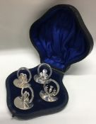 A boxed set of four pierced silver floral menu holders. Birmingham 1911. By Horace Woodward & Co.