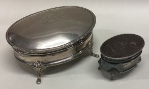 Two oval silver ring boxes with hinged lids.