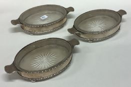CHESTER: A set of three oval silver butter dishes.