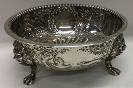 A heavy silver bowl with lion feet embossed with hunting scenes. London 1907.