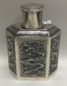 A Chinese export 19th Century silver tea caddy embossed with dragons and bamboo.