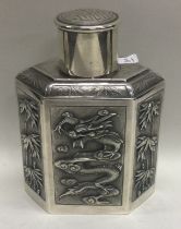 A Chinese export 19th Century silver tea caddy embossed with dragons and bamboo.