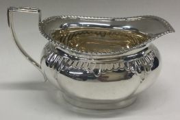 An Edwardian silver cream jug with fluted rim.