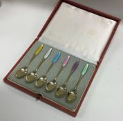 A cased set of silver gilt and enamel spoons.