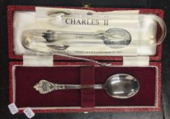A cased silver collectors spoon together with two pairs of tongs.
