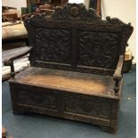 A carved oak monks bench.