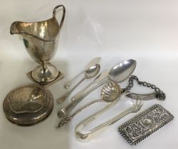 A collection of silver tongs, spoons, lids etc.