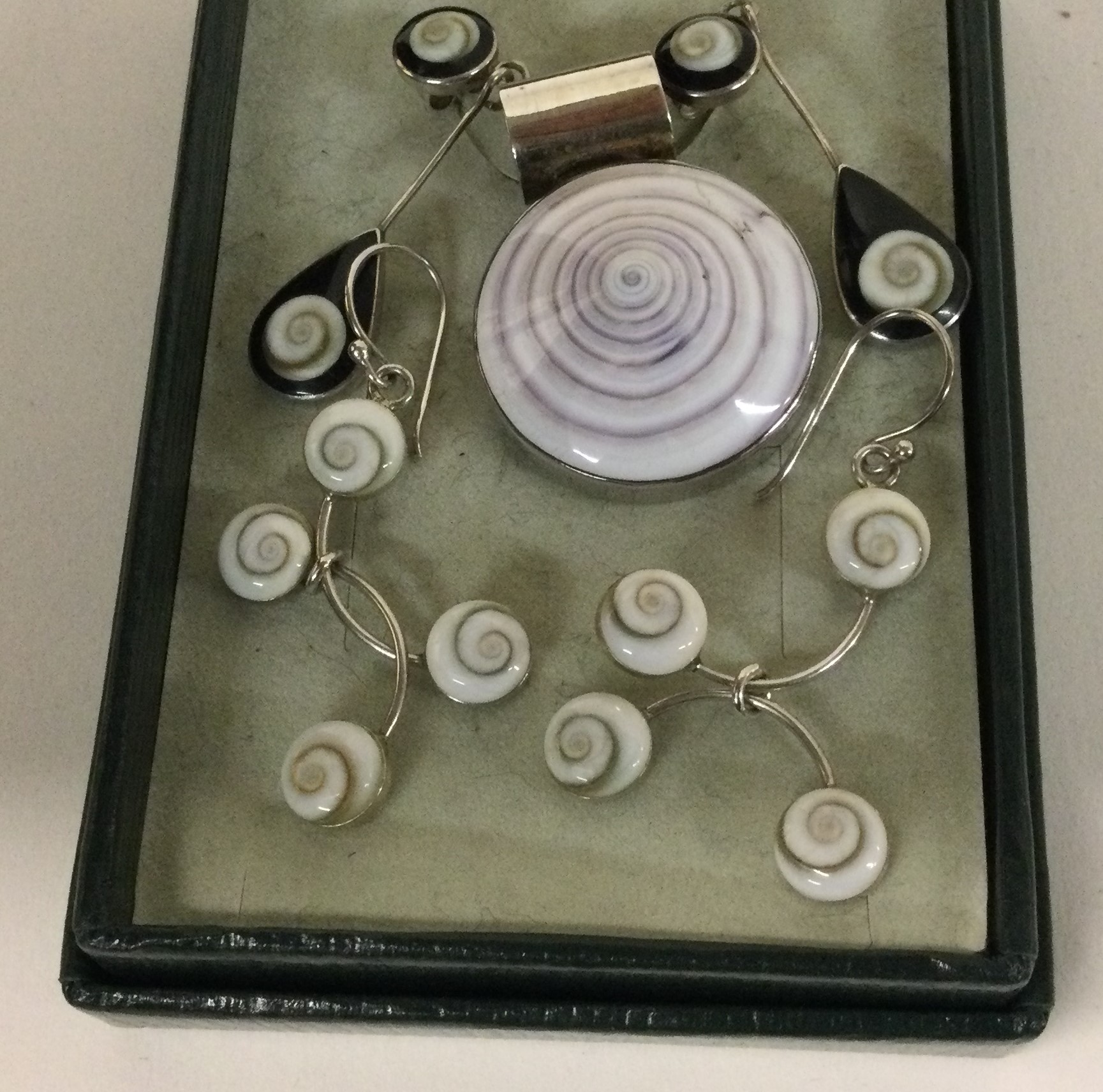 Two pairs of stylish silver ear pendants together with a pendant.