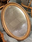 A large gilt framed oval mantle mirror.