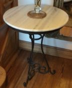 A marble top table on wrought iron base.