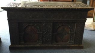 A massive Continental oak carved coffer with hinged top.