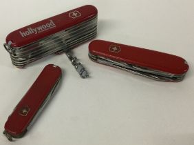 A large multi-functional Swiss army knife together with two others.