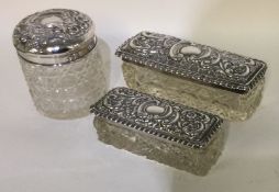Two rectangular silver scent bottles together with a circular example.