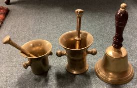 Two brass pestle and mortars together with a hand bell.