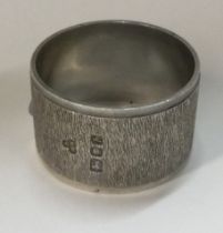 A novelty silver napkin ring with bark finish.
