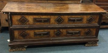 A large Continental hinged top coffer with carved panels to bracket feet.