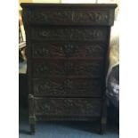 An Antique oak carved six drawer chest.