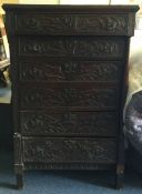 An Antique oak carved six drawer chest.