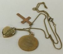 A heavy gold St Christopher together with a locket etc.