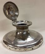 A large silver inkwell with hinged lid.