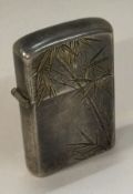 A Japanese silver lighter engraved with bamboo.