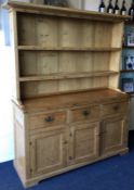 A good quality stripped pine three drawer kitchen dresser with open back.