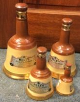 A set of four graduating sized bell shaped bottles of Bell's Blended Scotch Whisky.