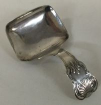 A George III silver caddy spoon with vine pattern.