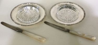 A good pair of silver mounted butter dishes together with knives.