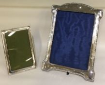 A large arched top silver picture frame together with a smaller example.