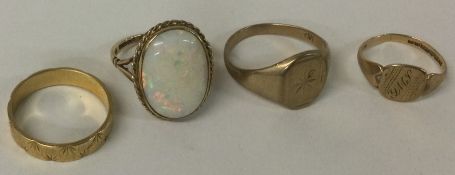 An opal single stone ring together with three other gold bands.