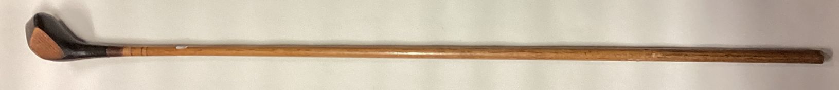 An old tapering wooden golf club.