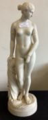 A tall alabaster figure of a lady.