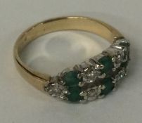 An emerald and diamond two row ring in 9 carat setting.