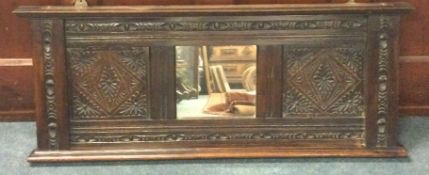 A carved oak overmantle mirror.