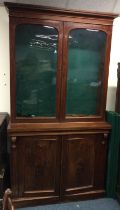 A good tall Victorian glazed bookcase with scroll decoration.