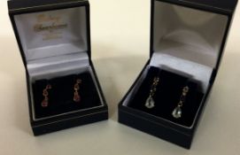 A pair of 9 carat sapphire mounted ear pendants together with a pair of ruby drop ear pendants.