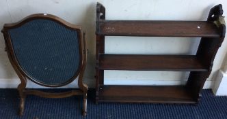 A small shield shaped mirror together with a mahogany wall bracket.