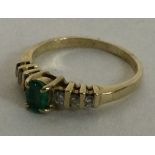 A small emerald and diamond seven stone ring in 9 carat mount.