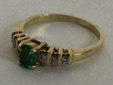 A small emerald and diamond seven stone ring in 9 carat mount.