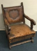 A small leather chair with carved handles. Est. £3