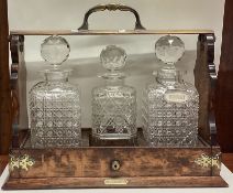A good oak and brass mounted three bottle tantalus.