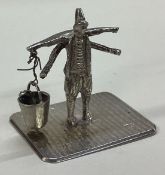 A silver figure of a man holding a bucket.