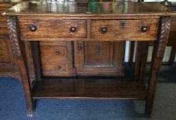 A good carved oak two drawer side table on fluted supports.